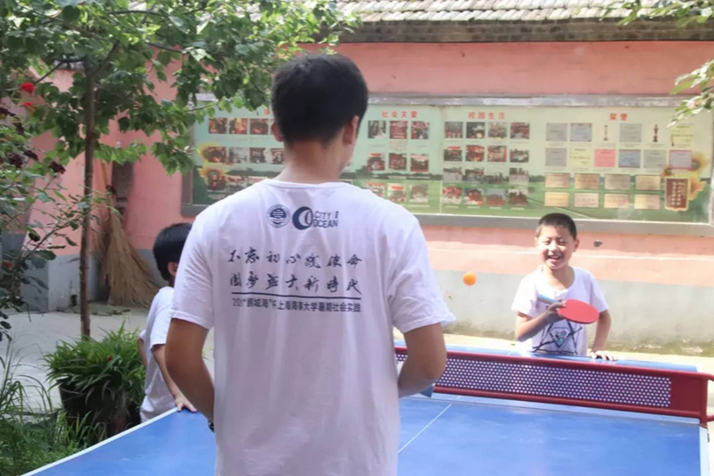 开心地跟老师打乒乓球的孩子