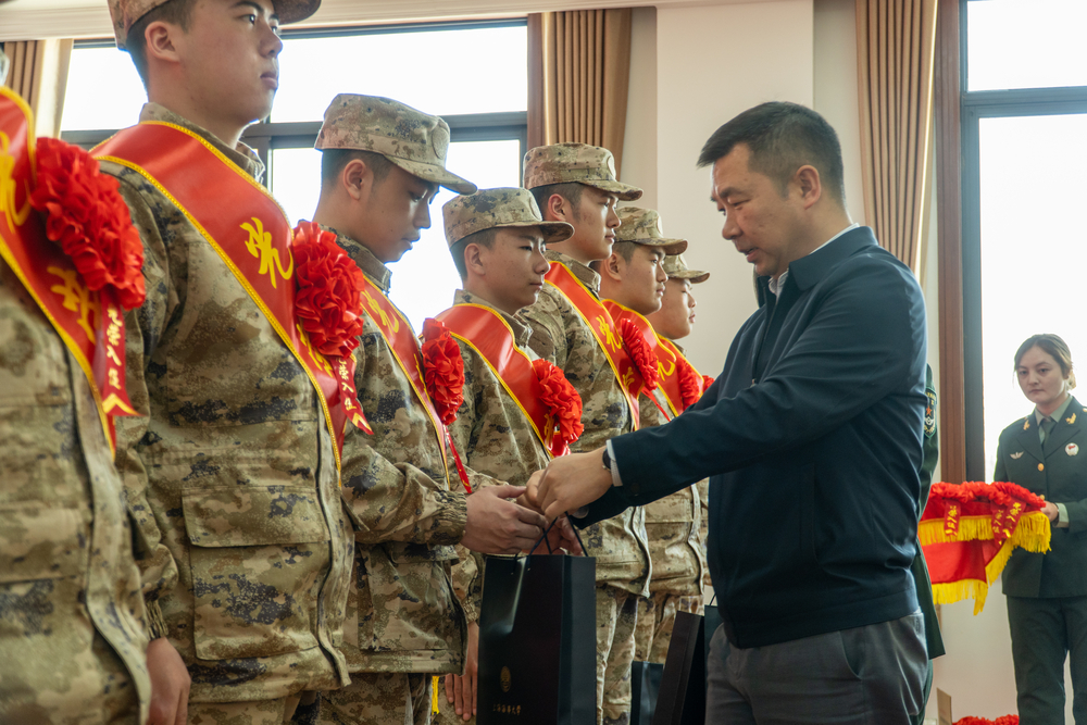 李志鹏为入伍学生佩戴大红花并发放慰问品