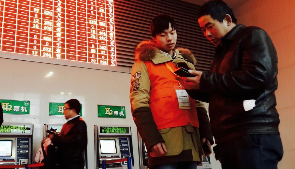 志愿者协助旅客查询列车班次
