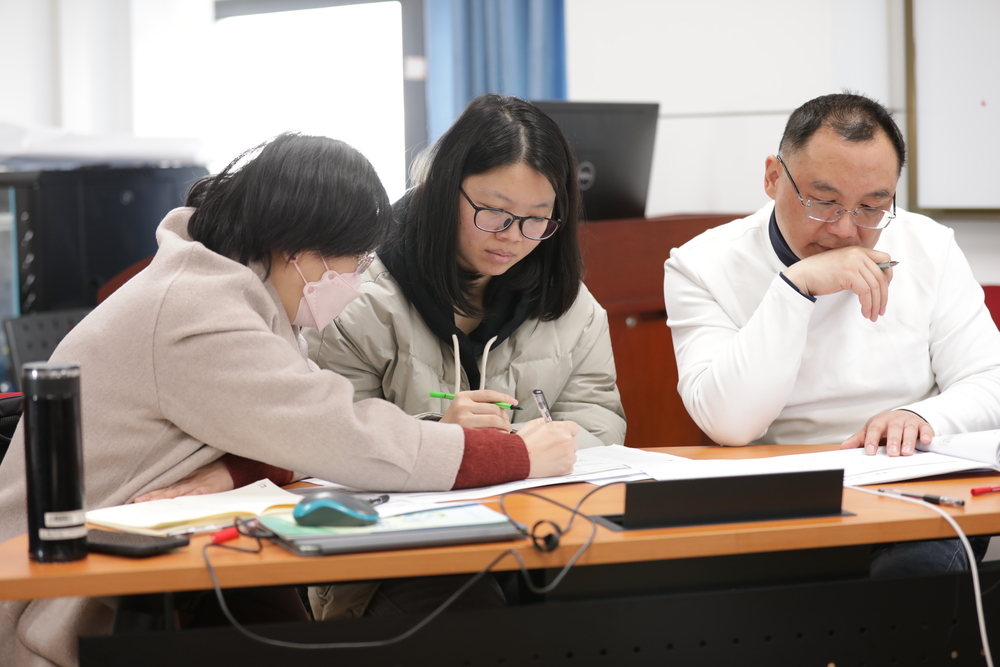 张琴（左一）与焦佳佳副教授（左二）在试点班培训现场研讨教学案例